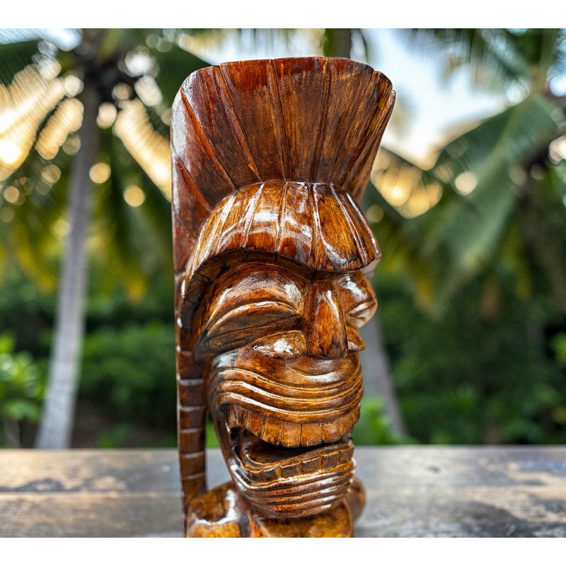 Wooden tiki statue with a tropical background