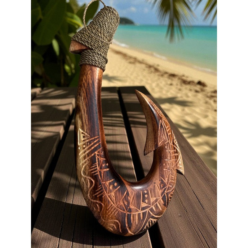 Wooden hook with carvings on a wooden surface by a beach