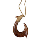 Wooden fish hook pendant on a rope against a white background