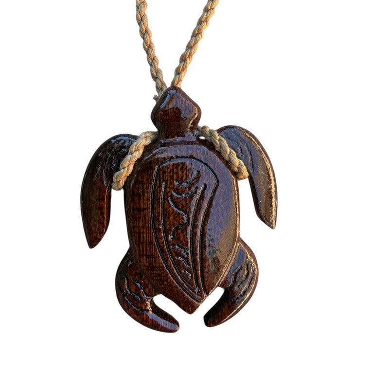 Wooden turtle pendant on a rope against a white background