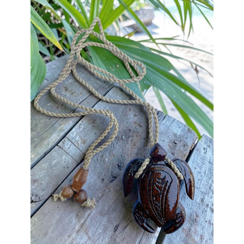 Decorative turtle ornament with rope on a wooden surface
