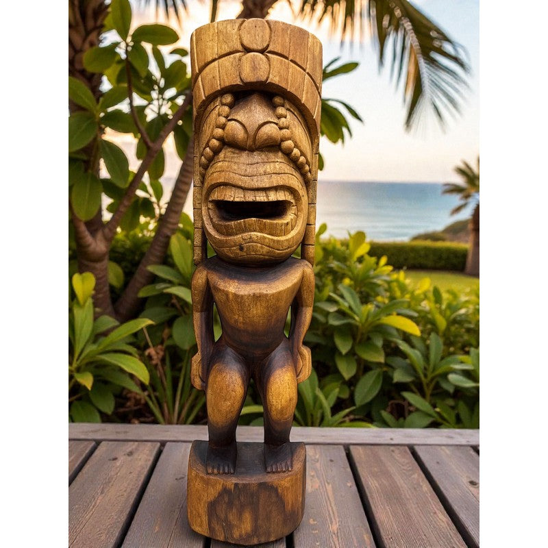 Wooden tiki statue on a wooden surface with a garden and ocean view in the background