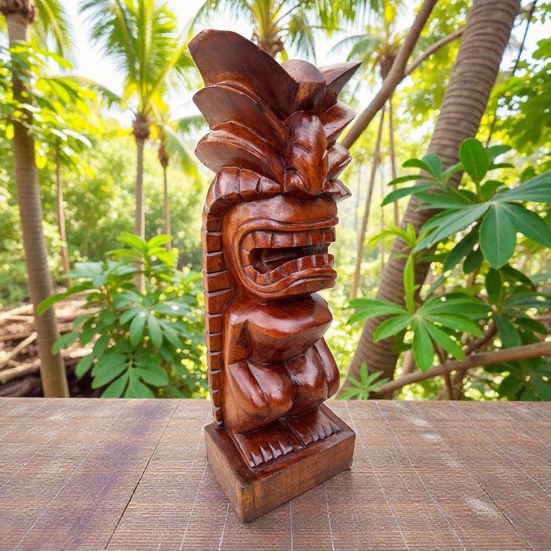 Wooden tiki statue on a table with a tropical background