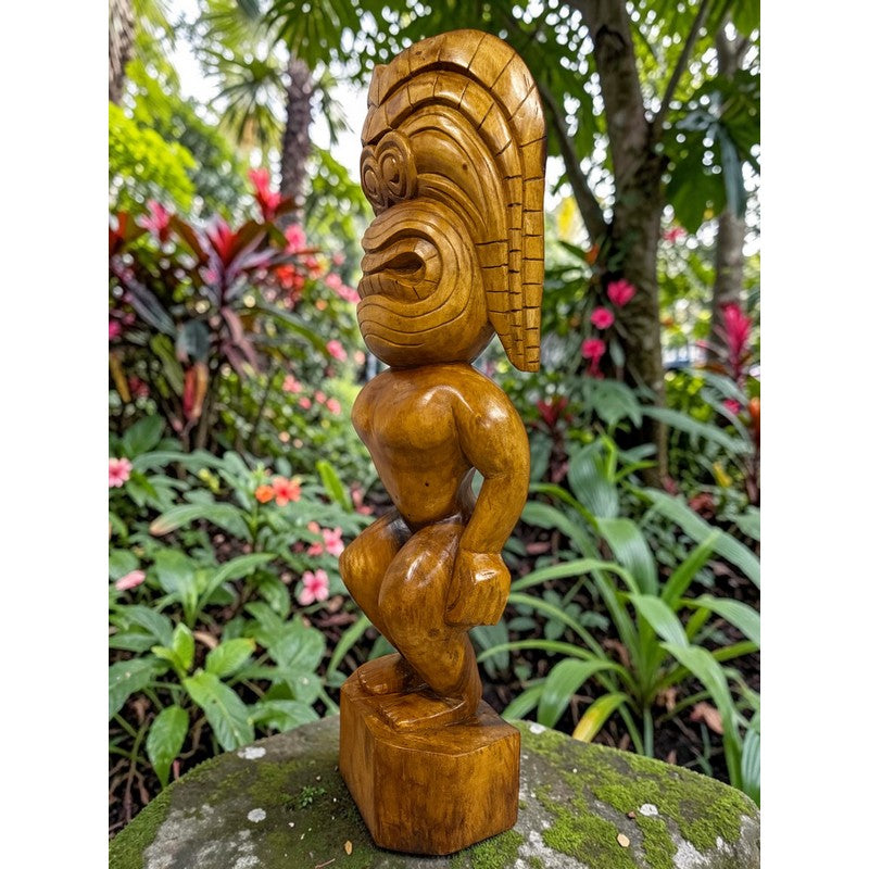 Wooden sculpture of a figure with a headdress in a garden setting
