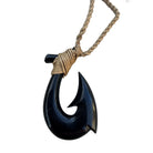 Black fish hook pendant on a braided rope against a white background