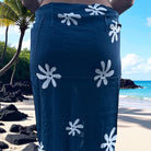 Blue sarong with white floral patterns on a beach