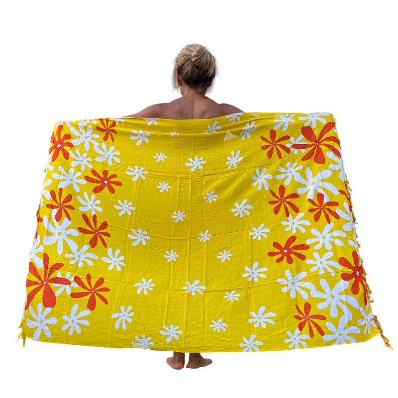 Person wearing a yellow floral patterned towel on a white background