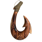 Wooden fish hook with intricate carvings on a white background