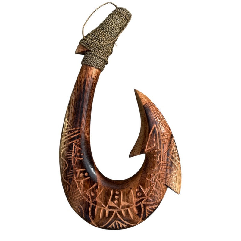 Wooden fish hook with intricate carvings on a white background