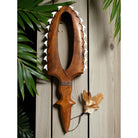 Wooden weapon with a feather on a wooden background