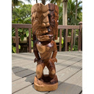 Wooden tiki statue on a wooden deck with a tropical background