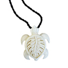 White turtle pendant on a black cord against a white background