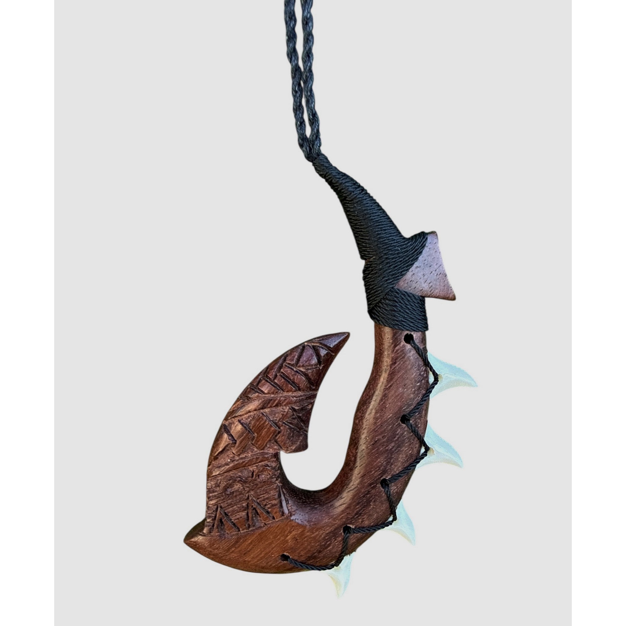 Wooden fish hook pendant on a white background
