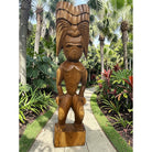 Wooden tiki statue in a tropical garden setting