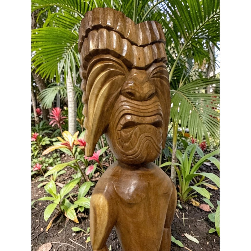 Wooden tiki statue in a tropical garden setting