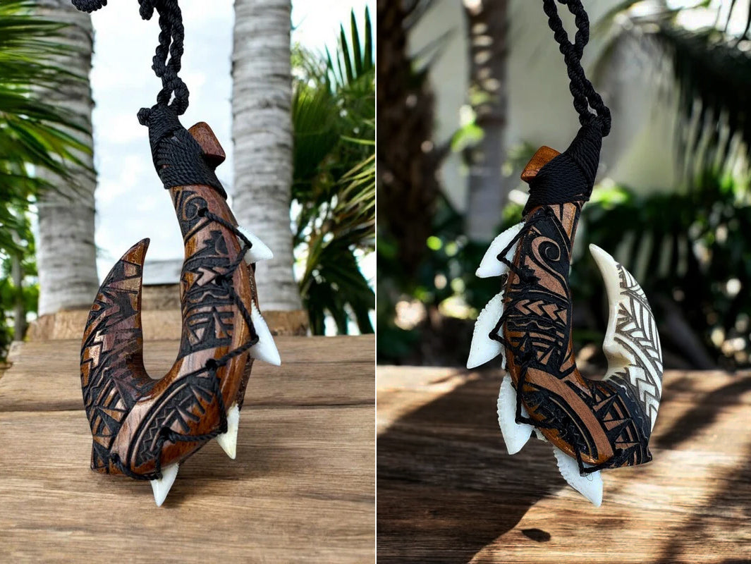 Decorative fish hook with tribal patterns on a wooden surface with palm trees in the background.
